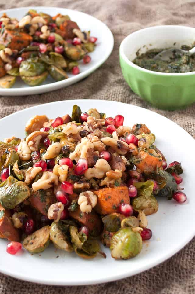 A roasted side dish fit for fall with Brussels sprouts and sweet potatoes with a fall-friendly pesto and walnuts.