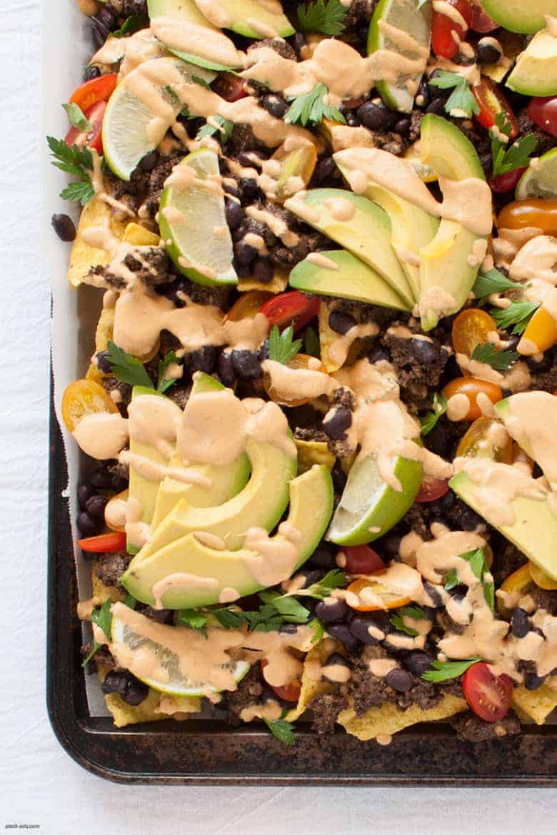 Get your nacho on with these vegan friendly nachos, topped with a cheesy vegan sauce. | Vegan Sheet Pan Nachos from small-eats.com