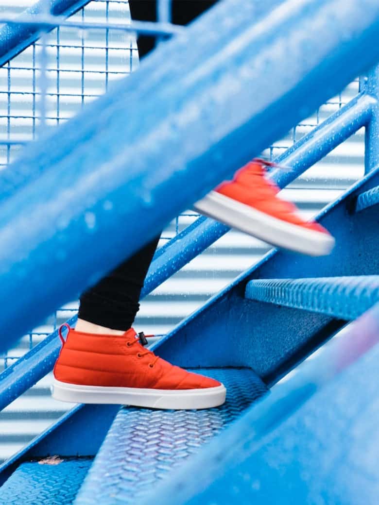 Orange sneakers walking up blue steps